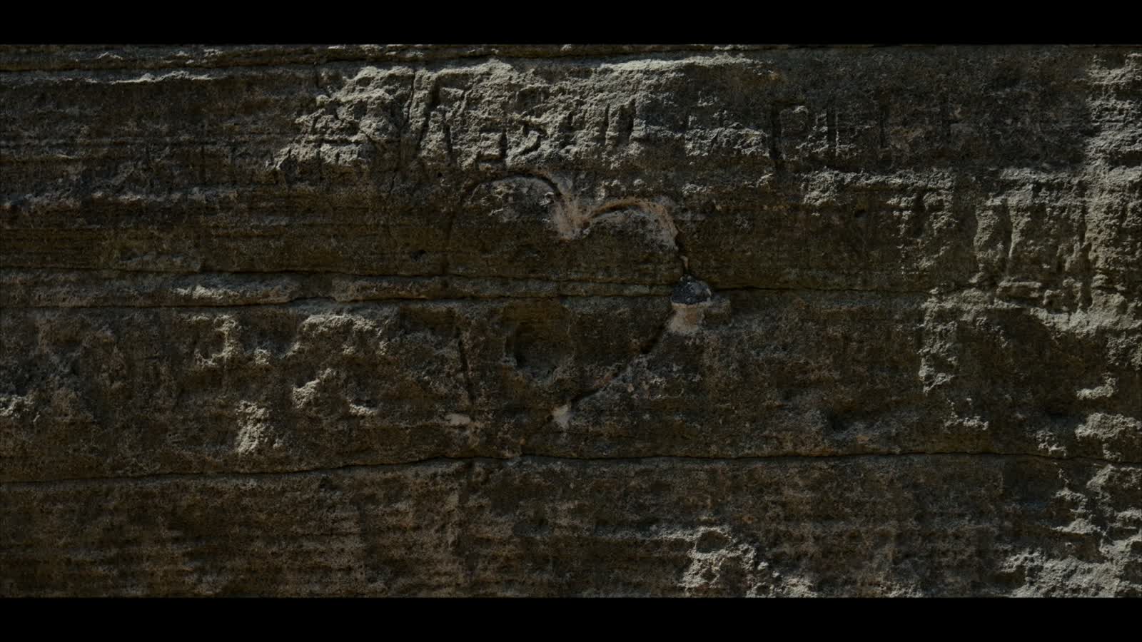 Un nombre y un corazón rayados en la pared de la cueva